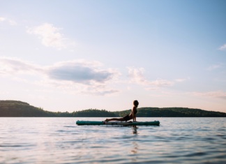 SUP Yoga. Wolf SUP Yoga practices upward facing dog on her paddleboard